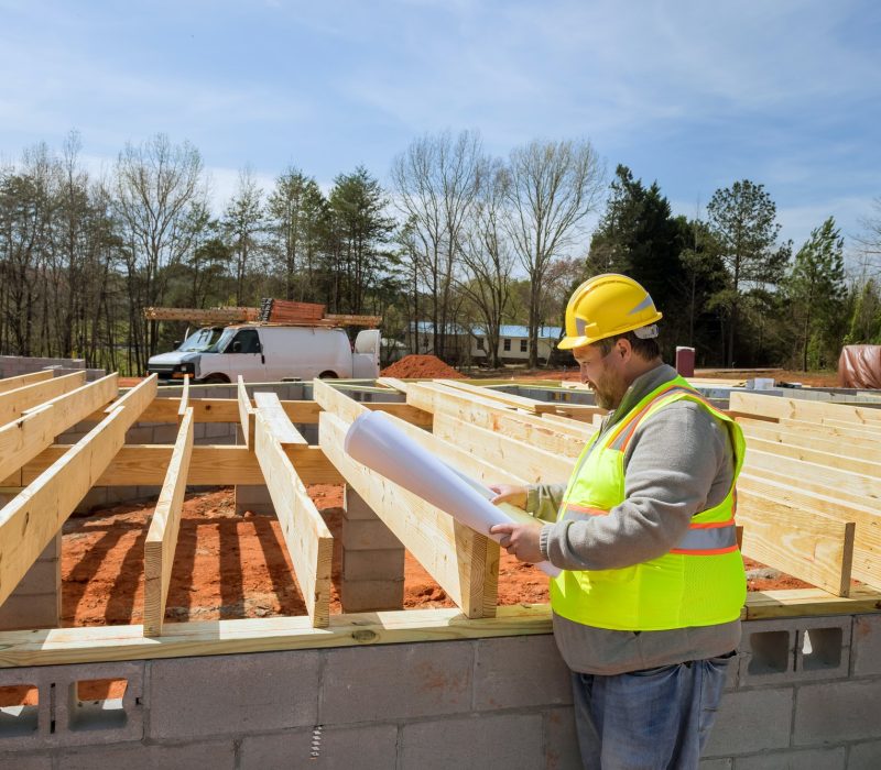 Construction engineers check a construction of new homes using construction blueprint plans